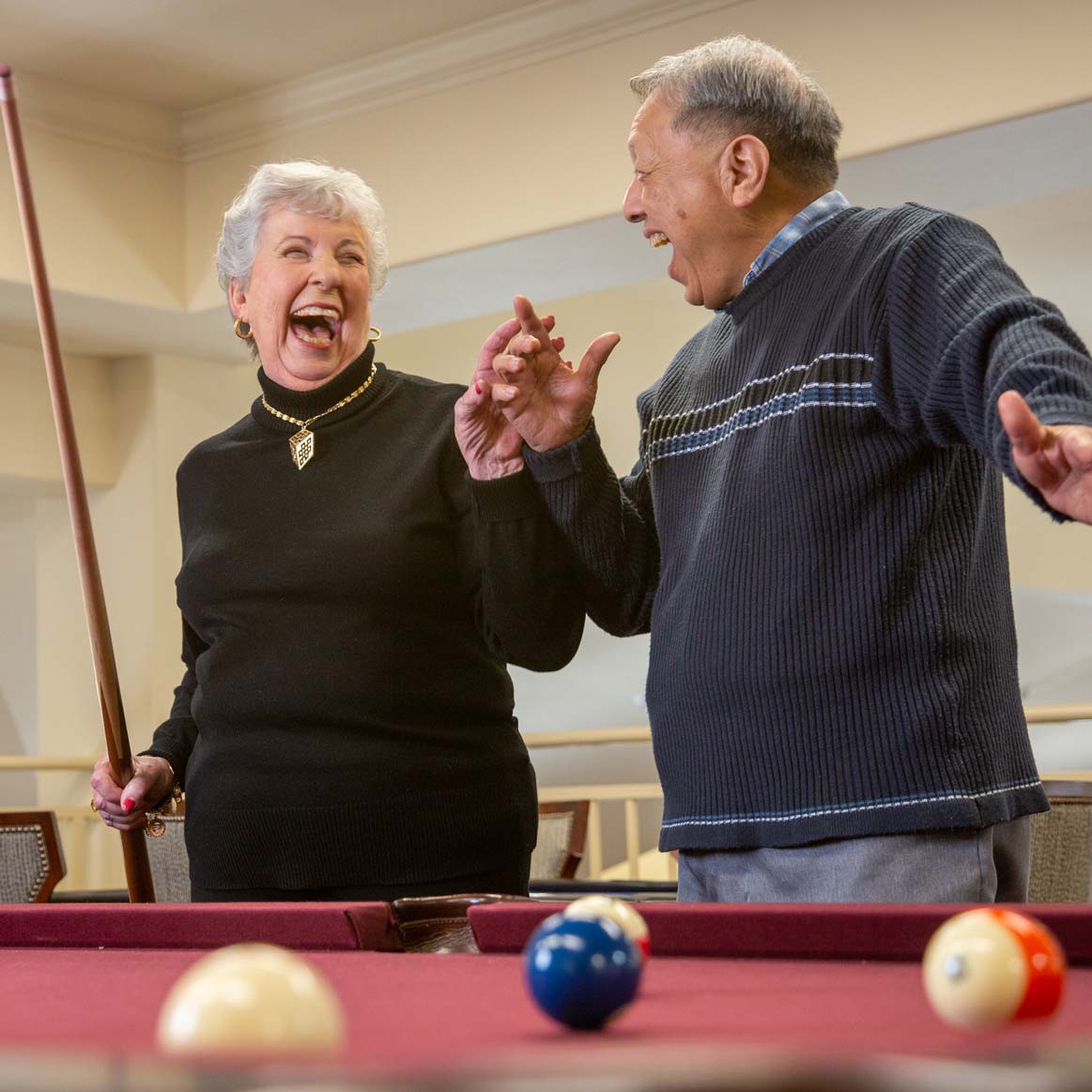 Residents playing billiards at Meadowlark Estates